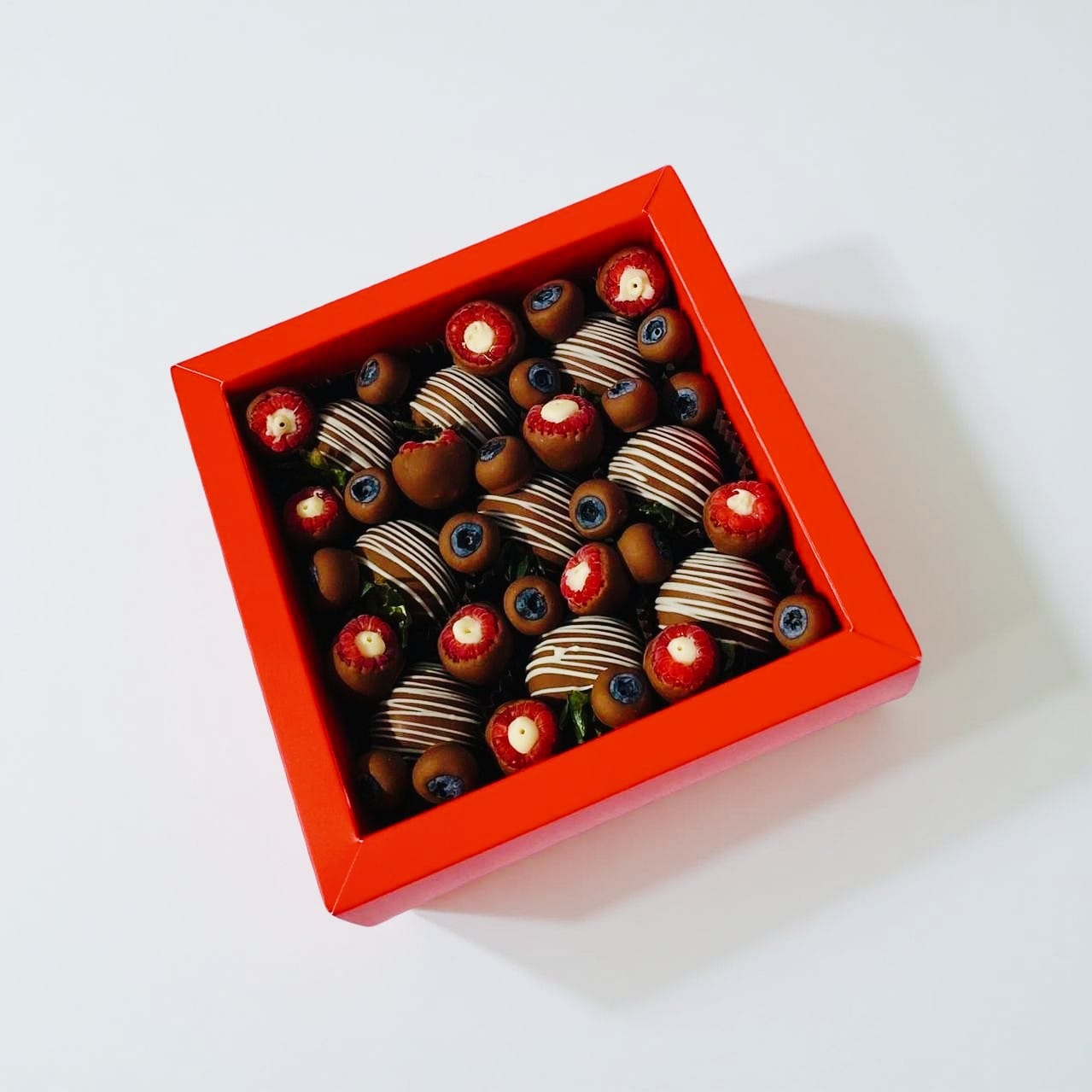 Mira Box – milk chocolate strawberries with white drizzle, paired with raspberries and blueberries, Dubai gift box